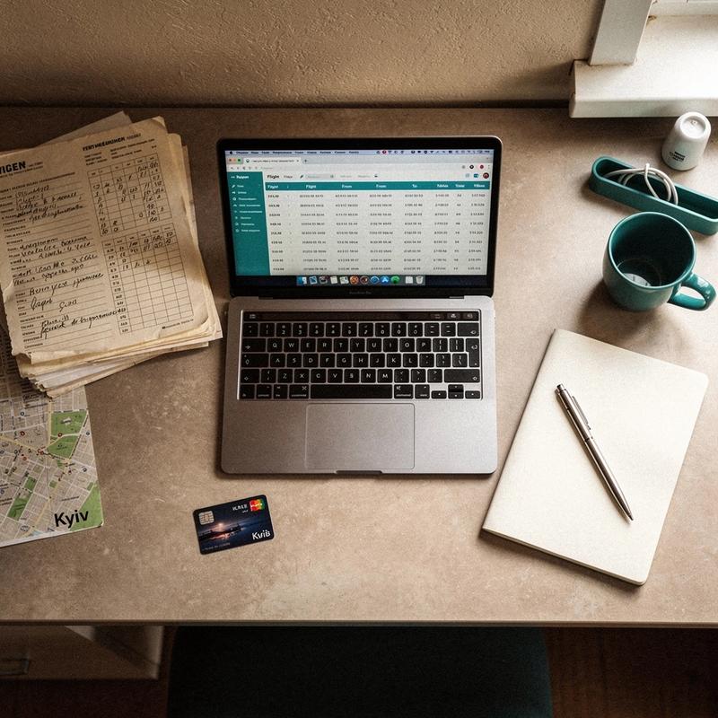 Coordinator desk with itinerary ledgers and a laptop in the Kyiv office