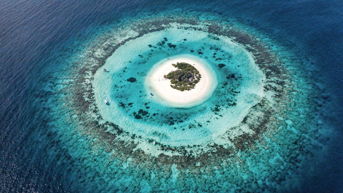 Aerial view of a Maldives atoll with turquoise lagoon and sandbank